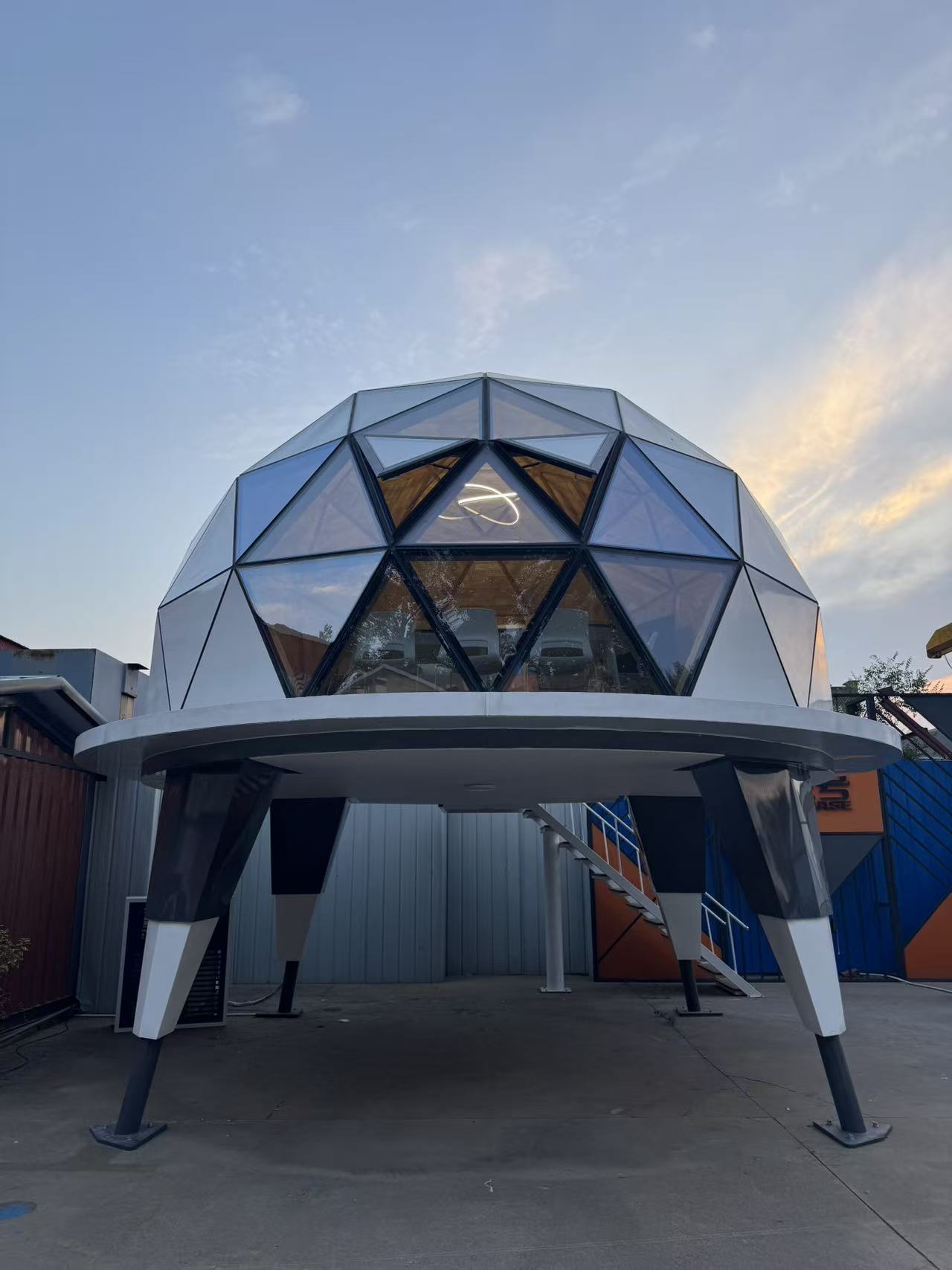 Front view of the bahria homes House C7 Plus elevated geodesic dome with glass and metal structure, highlighting innovative smart pod architecture at sunset.