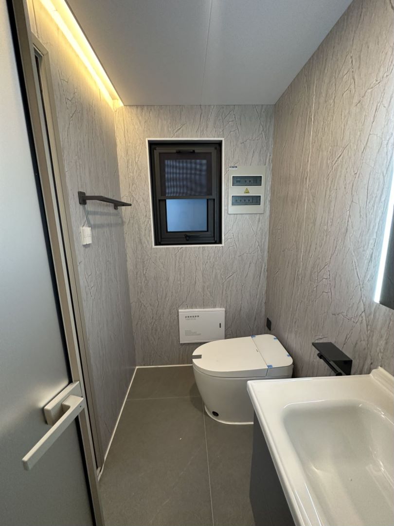 Interior of the bahria homes House D8 featuring a sleek, modern bathroom design with a smart toilet, wall-mounted sink, and soft ambient lighting.