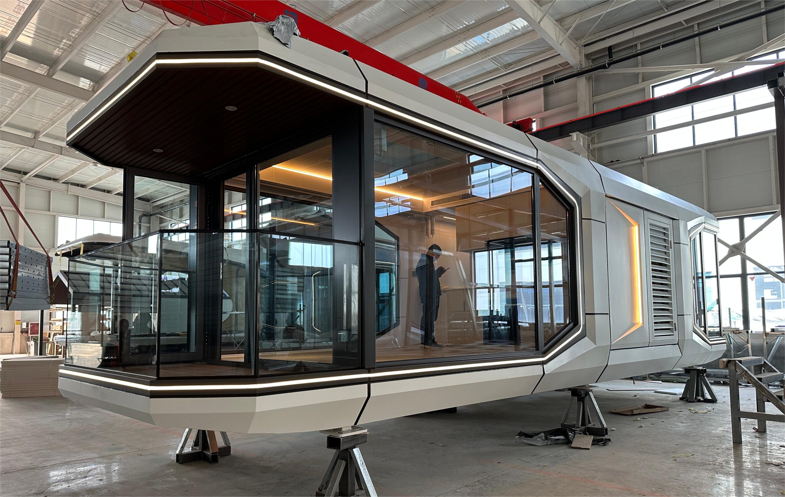 bahria homes House D7 modular smart pod under assembly, featuring large glass panels, LED lighting, and advanced architectural design in a modern production facility.