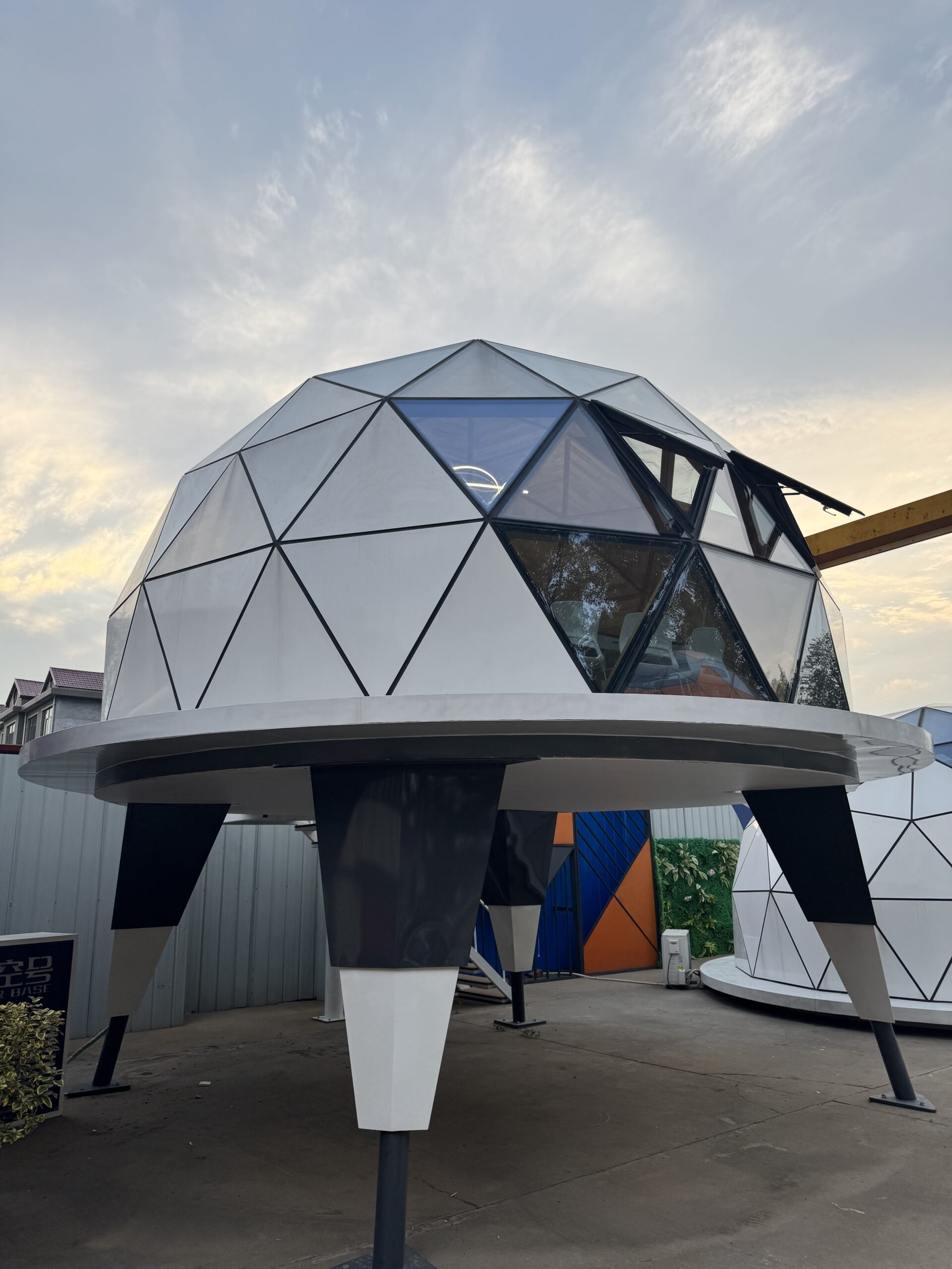Side view of the bahria homes House C7 Plus elevated geodesic dome pod with open glass window panels, showcasing futuristic modular architecture by bahria homes Castle.