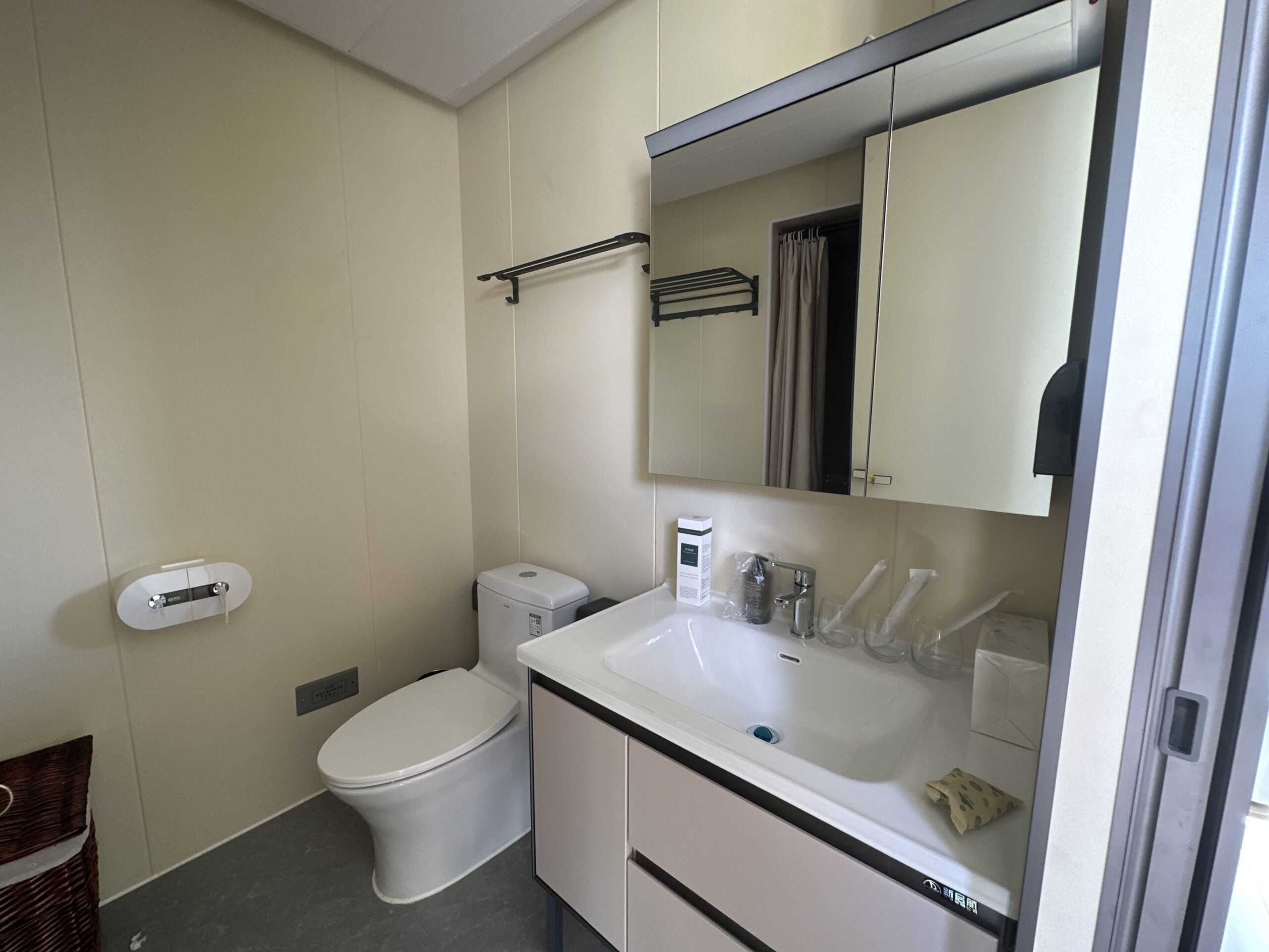 Interior of the bahria homes House D7 bathroom featuring a sleek white sink, toilet, mirrored cabinet, and minimalist modern design with practical fixtures.